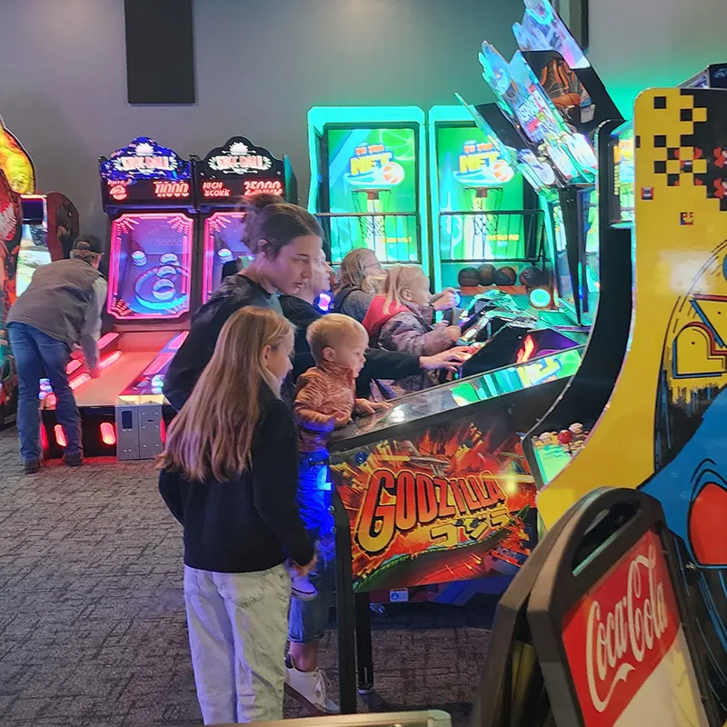 Families playing arcade games at a multi-activity entertainment venue