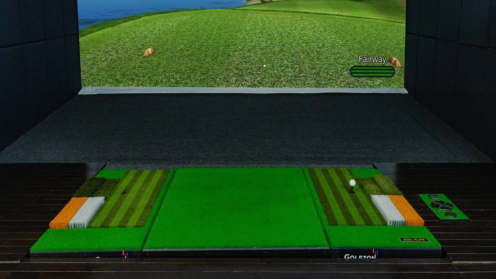 Golf simulator bay with a dual hitting plate, turf mats and the impact screen