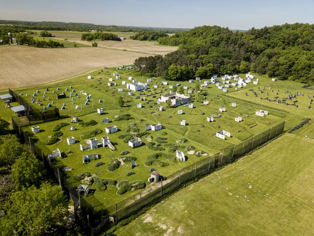 Aerial view of a large outdoor paintball park with multiple fields and bunkers
