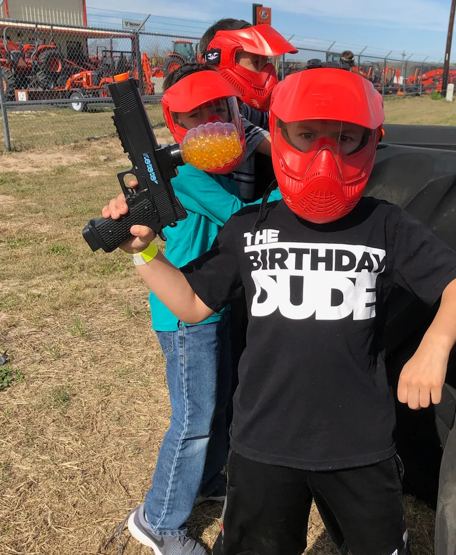 Kids in masks at an outdoor birthday party game