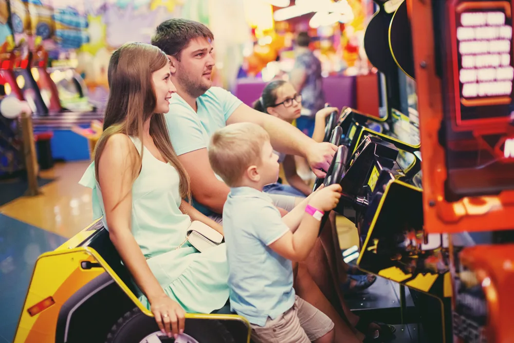 Family playing an arcade game at a multi-activity entertainment center